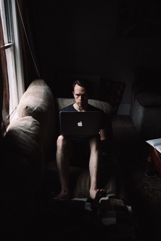 A person sitting in a dark room
Description automatically generated