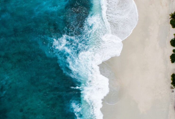Aerial view of waves on a white sand beach; cover image for blog on how to interpret feedback to develop leader character.