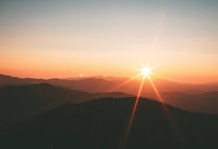 A sunrise over mountains representing women athletes' rise to the C-suite.