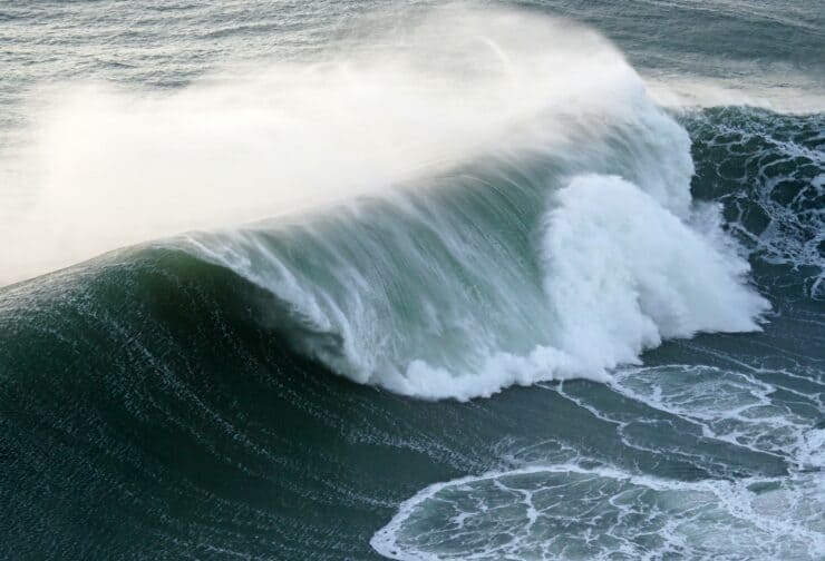 Large ocean wave building under pressure, representing the buildup of leadership burnout beyond visible symptoms.